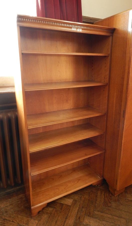 A modern open bookcase with dentil cornice and six adjustable shelves, raised on bracket feet,