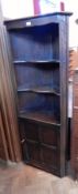 A stained oak reproduction corner cupboard with open shelf top,