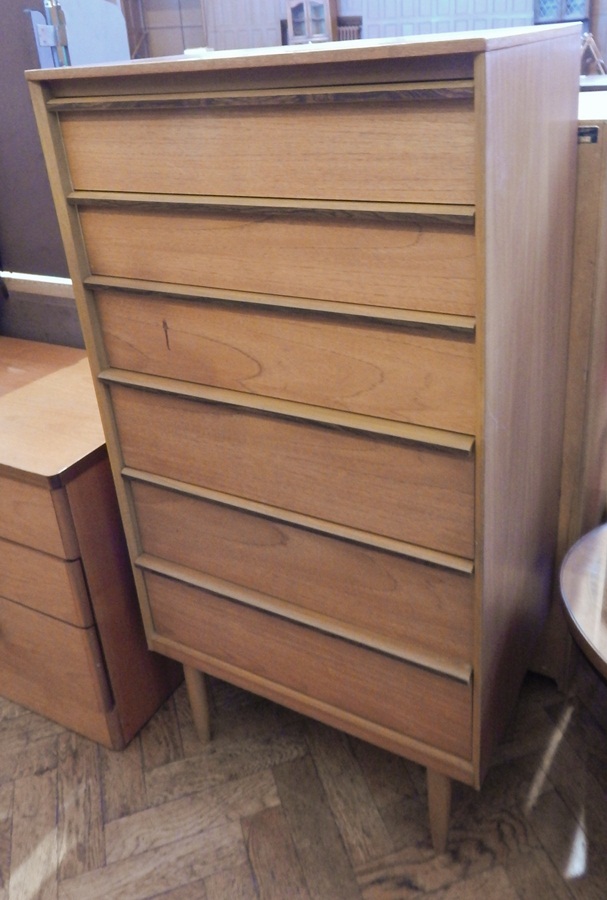 Modern chest of six drawers raised on turned tapering legs,