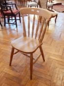 A set of six beech spindle back kitchen chairs with solid seats on turned tapering legs with