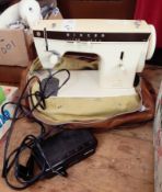 An electronic Singer sewing machine within a carry case and various sewing items including buttons,