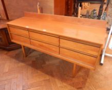 A circa 1960's hardwood mirror-back dressing table of six drawers, on turned tapering legs,