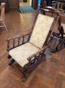 A late Victorian platform rocking chair, with turned column support, panel back and seat,