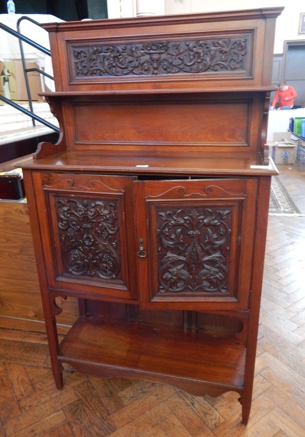 A late Victorian walnut side cabinet, the back with open shelf and carved foliate panel,