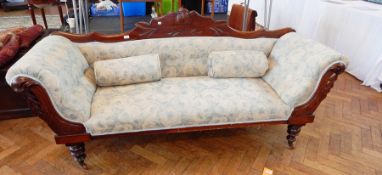 A late Victorian carved mahogany framed sofa, with blue and white floral upholstery,