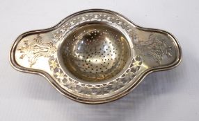 Silver tea strainer with floral pierced fretwork border,