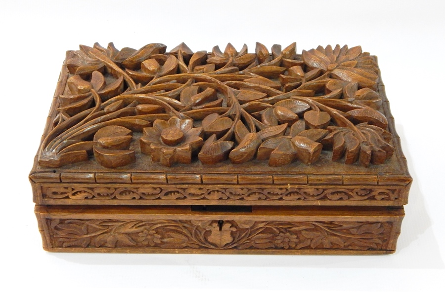 Eastern carved hardwood casket with naturalistic deeply carved floral spray to hinged lid,