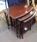 Nest of three mahogany bowfronted occasional tables with formal leaf borders,