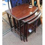 Nest of three mahogany bowfronted occasional tables with formal leaf borders,