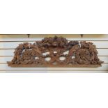 Carved oak pediment with floral and scroll design centred by floral display and eagle head supports,