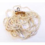 Seedpearl multi-strand necklace with engraved gold-coloured metal hinged barrel-shaped clasp