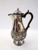 Eastern white metal coffee pot of baluster form, with foliate decoration, raised on a circular foot,