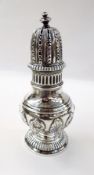 Victorian silver sugar caster with foliate repousse decoration, raised on a reeded circular foot,