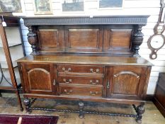 Jacobean style oak sideboard, the fluted and fielded panel back with carved cup and over supports,