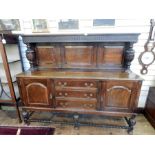 Jacobean style oak sideboard, the fluted and fielded panel back with carved cup and over supports,