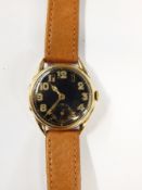 Gent's gold-coloured wristwatch with circular black dial, luminous hands and Arabic numerals,