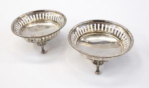 Pair of George V silver bonbon dishes with reed borders, openwork design, raised on toed feet,