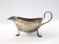 George V silver gravy boat with cut card borders, raised on cabriole legs with pad feet,