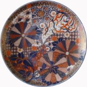 A Japanese Imari charger decorated stylised chrysanthemums with a foliate border,
