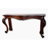 A Victorian rosewood serpentine side serving table on stout cabriole legs, carved foliate knees,
