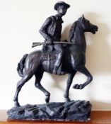 A cold cast bronzed figure of a cowboy mounted on horseback, holding rifle,