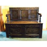 An oak settle with lunette and rose three-panelled back,