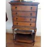 A 1920's oak four-drawer music cabinet on bobbin turned supports and work undertier,