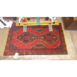 A Persian type small rug the red ground with central motifs
