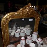 A gilted wall hanging mirror with carved crest