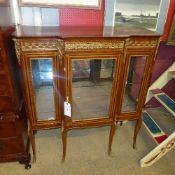 A French design walnut vitrine with gilt metal embellishments and glazed panel doors raised on