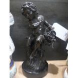 A bronze style model of a young boy on circular marble base