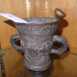 A bronze mortar and pestle with coat of detail