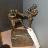 A bronze cast of kick boxers on marble base