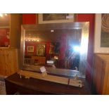 A rectangular silvered framed Art Deco style mirror having a bevelled plate 107 x 77 cm