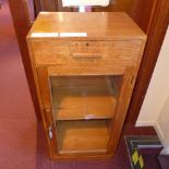 An oak side cabinet fitted single drawer above pair of panel doors on plinth base