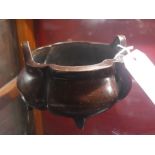 A Chinese bronze twin handled bowl raised on three feet