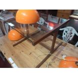 A Danish style low table the square glass top raised on teak supports