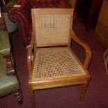 A cherrywood elbow chair with caned back and seat raised on square tapering supports