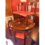 A designer rosewood dining table the circular top raised on four column base and the four matching