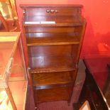 An oak open bookcase of narrow proportions