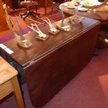 A George III mahogany drop flap dining table raised on reeded supports