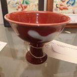 A Chinese stem bowl with white decoration on a red ground