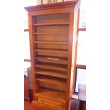 A pine open bookcase of narrow proportions and fitted single base drawer