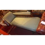 An Edwardian carved mahogany chaise longue upholstered in green fabric on turned supports