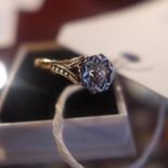 An Art Deco solitaire diamond and gold ring in a white metal mount