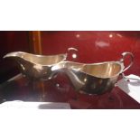 A pair of hallmarked silver sauce boats raised on pad feet