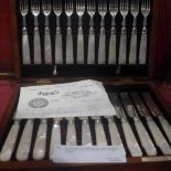 An oak cased complete set of twelve hallmarked silver fruit knives and forks with mother of pearl