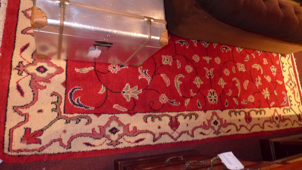 A handmade Persian rug with a red field surrounded by a frieze border 267 cm x 154 cm