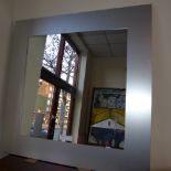 A contemporary wall mirror the square plate within steel frame