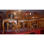 A set of four dining chairs with pierced backs above stuffover seats